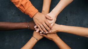 diverse people stacking hands together